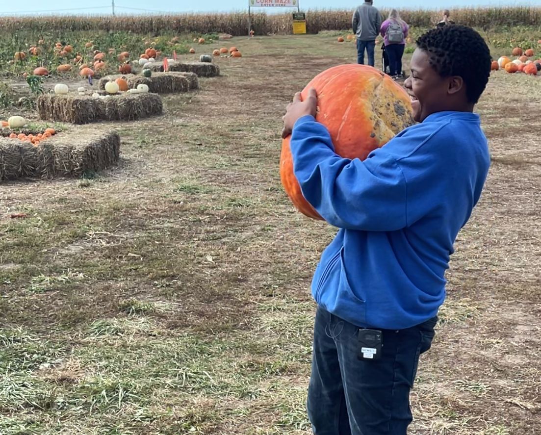 Denzel picking up a pumpkin